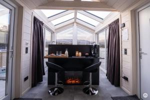 a room with a fireplace in a house with windows at Flatmoen Natur Lodge in Alta