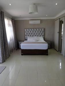 a bedroom with a large bed in a room at La Saville BnB in Scottburgh