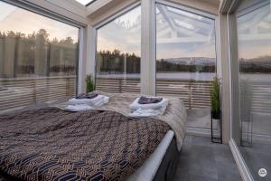 a bedroom with a bed in front of a window at Flatmoen Natur Lodge in Alta