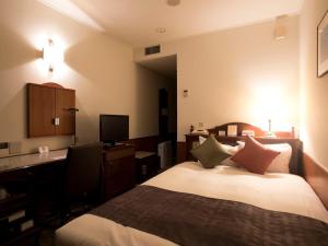 帯広市にあるプレミアホテル-CABIN-帯広のベッドとデスクが備わるホテルルームです。
