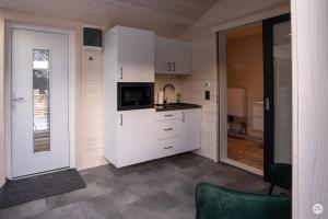 a small kitchen with white cabinets and a microwave at Flatmoen Natur Lodge in Alta