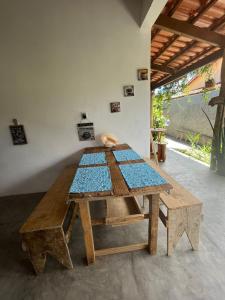 una mesa de madera en una habitación con banco y sidx sidx sidx en Pousada Casa de Naue - Ilha de Boipeba, en Isla de Boipeba
