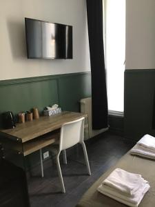 uma sala de jantar com uma mesa de madeira e uma cadeira em Hotel Geoffroy Marie Opéra em Paris