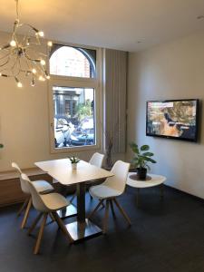 una sala da pranzo con tavolo e sedie e una finestra di Hotel D'Amsterdam Leidsesquare ad Amsterdam