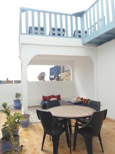 een woonkamer met een tafel en stoelen en een trap bij Riad Etoile De Mogador in Essaouira