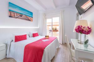1 dormitorio blanco con 1 cama con manta roja en Hotel Romerito, en Málaga