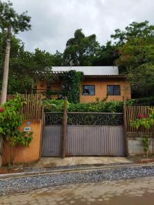 una casa dietro una recinzione con un cancello di Suíte aconchegante a Ilhabela
