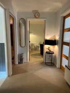 um corredor com um relógio na parede e um espelho em Atlantic apartment em Sidmouth