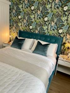 een slaapkamer met een groot bed met bloemenbehang bij No 73 Aparthotel by condokeeper in Cambridge