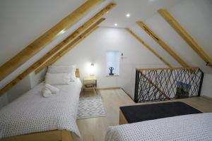 a attic room with two beds and a chair at Apartment Ispod ure in Sinj
