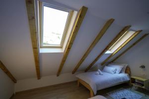 a attic room with a bed and a window at Apartment Ispod ure in Sinj