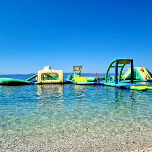 a group of slides in the water on a beach at Vila Maslina Apartments mit Pool und Garten nahe am Strand in Tučepi +24 photos
