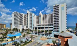 a large white building with palm trees and the ocean at Unit 2328 Ocean Walk - 2 Bedroom Ocean View in Daytona Beach