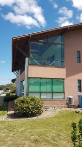 a building with a large window on the side of it at Flat no Canarius Residence - Gravatá in Gravatá