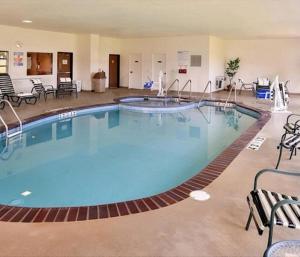 una gran piscina en una habitación de hotel con sillas y mesas en Holiday Inn Stevens Point - Convention Center, an IHG Hotel, en Stevens Point