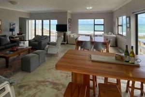 a living room with a view of the ocean at Bakgat Stay - Seafront 7-sleeper holiday home in Struisbaai