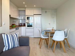 Tyba Deluxe Apartment في أليكانتي: مطبخ وغرفة طعام مع طاولة وكراسي