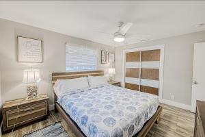 1 dormitorio con 1 cama y mesita de noche con lámpara en Two Palms B en North Palm Beach