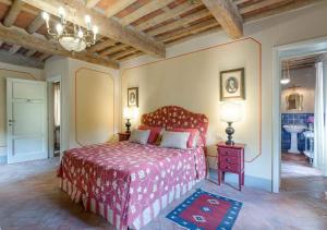 una camera con un letto con copriletto rosso di Casa del Fattore by MC Luxury Rentals a Capannori