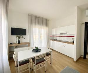 a kitchen with a white table and chairs in a room at Pietrasantamare in Marina di Pietrasanta