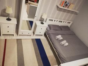a small bedroom with a bed and a mirror at Apartman Park in Subotica