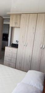 a bedroom with wooden cabinets and a white bed at Espectacular apartamento en Puerto Azul Club House in Ricaurte
