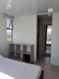 a white bedroom with a bed and a window at Espectacular apartamento en Puerto Azul Club House in Ricaurte