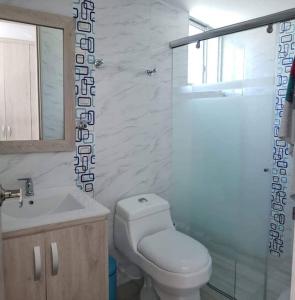 La salle de bains est pourvue de toilettes, d'un lavabo et d'une douche. dans l'établissement Espectacular apartamento en Puerto Azul Club House, à Ricaurte