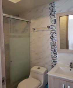 a bathroom with a white toilet and a sink at Espectacular apartamento en Puerto Azul Club House in Ricaurte