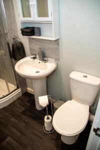 a bathroom with a white toilet and a sink at Cosy Convenient 1 BR Flat at Central Stoke Near Hospitals and Univesities in Stoke on Trent