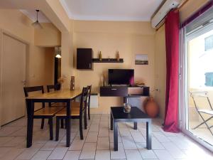 a dining room with a table and a tv at Menecrates Corfu Town Apartment in Corfu