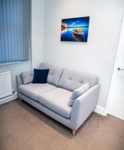 a couch in a living room with a picture on the wall at Cosy Convenient 1 BR Flat at Central Stoke Near Hospitals and Univesities in Stoke on Trent