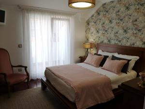 a bedroom with a large bed with a floral wallpaper at Atico C&E Cambados in Cambados