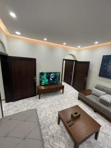 a living room with a couch and a flat screen tv at شقق سما العلا in AlUla