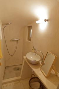 a bathroom with a sink and a shower and a mirror at Castelli Porta in Emporio Santorini