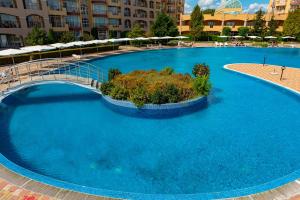 uma grande piscina azul com uma ponte em Menada Grand Resort Apartments em Aheloy