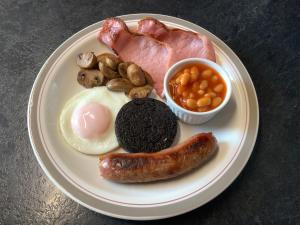 un plato de desayuno con huevos beicon y judías en Southbank Guesthouse en Elgin