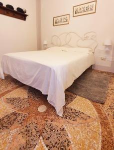 Relais Pacinotti Rooms في بيزا: غرفة نوم عليها سرير وبطانية بيضاء