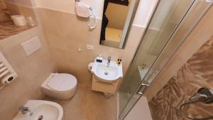 a bathroom with a toilet and a sink and a shower at Relais Pacinotti Rooms in Pisa