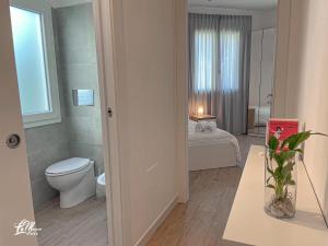 a bathroom with a toilet and a bedroom with a bed at La Maison Fois - Appartamento Quartucciu in Quartucciu