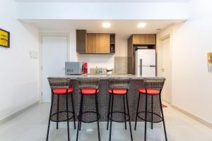 una cocina con barra con taburetes rojos en In Mare #26 - Apartamento na Praia por Carpediem, en Parnamirim