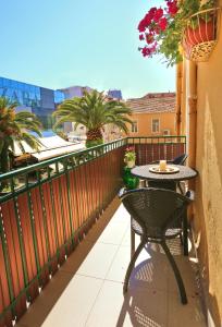 a table and chair on a balcony with a view at Apartments Marmont in Split