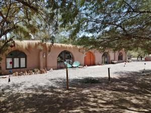 a large building with a tree in front of it at CaminAndes Hostal in San Pedro de Atacama