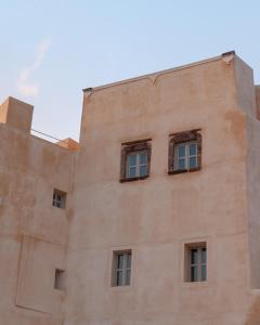 a building with three windows on the side of it at Castelli Porta in Emporio Santorini
