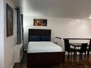 1 dormitorio con 1 cama, mesa y sillas en Vakb Apartments, en Brooklyn
