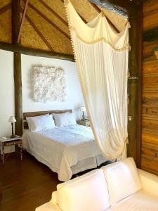 1 dormitorio con 1 cama con mosquitera en Bangalo a beira do rio em plena natureza, en Petrópolis