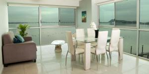 comedor con mesa de cristal y sillas en Riverfront II, piso 2, suite vista al rio, Puerto Santa Ana, Guayaquil, en Guayaquil
