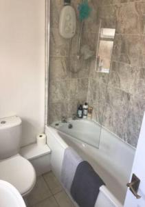 a bathroom with a tub and a toilet and a shower at 4 Bedroom House For Corporate Stays in Kettering in Kettering
