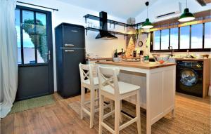 a kitchen with a bar with two white stools at Cozy Home In Mejannes Les Alès in Méjannes-lès-Alès +36 photos