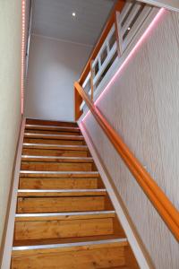 uma escadaria com pisos de madeira e um corrimão de madeira em Annam House em Bad Sooden-Allendorf